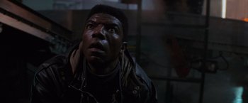 Movie still from “Die Hard 2” (1990), directed by Renny Harlin – A man with a black jacket looking up at the sky; Close Up shot, Low angle