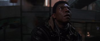 Movie still from “Die Hard 2” (1990), directed by Renny Harlin – A man in a leather jacket looking up at the sky; Close Up shot, Low angle