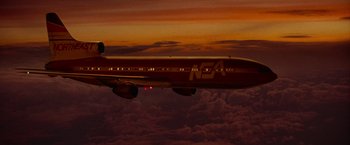 Movie still from “Die Hard 2” (1990), directed by Renny Harlin – An airplane is flying through the sky at sunset; Extreme Wide shot, Low angle