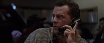 Movie still from “Die Hard 2” (1990), directed by Renny Harlin – A person talking on a cell phone; Close Up shot, Low angle