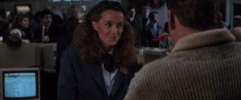 Movie still from “Die Hard 2” (1990), directed by Renny Harlin – A woman in a suit and bow tie is talking to a man; Close Up shot, Over the shoulder angle