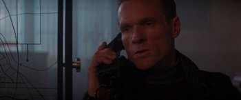 Movie still from “Die Hard 2” (1990), directed by Renny Harlin – A person talking on a cell phone; Close Up shot, Low angle