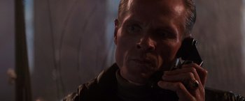 Movie still from “Die Hard 2” (1990), directed by Renny Harlin – A person talking on a cell phone; Close Up shot, Low angle