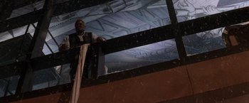 Movie still from “Die Hard 2” (1990), directed by Renny Harlin – A man standing on top of a building looking up; Wide shot, Low angle