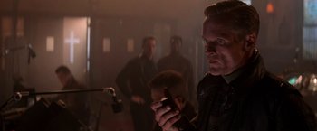 Movie still from “Die Hard 2” (1990), directed by Renny Harlin – A group of men standing in a dark room; Close Up shot, Over the shoulder angle