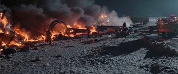 Movie still from “Die Hard 2” (1990), directed by Renny Harlin – A fire is burning in the middle of the night; Extreme Wide shot, High angle