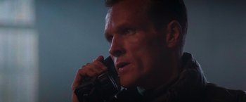 Movie still from “Die Hard 2” (1990), directed by Renny Harlin – A person talking on a cell phone; Close Up shot, Low angle