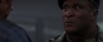 Movie still from “Die Hard 2” (1990), directed by Renny Harlin – A person wearing a uniform; Close Up shot, Over the shoulder angle