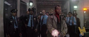 Movie still from “Die Hard 2” (1990), directed by Renny Harlin – A group of men standing next to each other in a room; Medium shot, Low angle