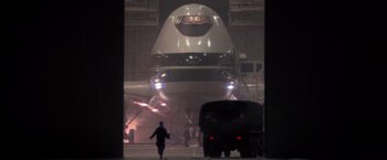 Movie still from “Die Hard 2” (1990), directed by Renny Harlin – An airplane is parked on the runway at night; Extreme Wide shot, Low angle