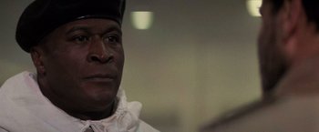 Movie still from “Die Hard 2” (1990), directed by Renny Harlin – A person wearing a white shirt; Close Up shot, Low angle