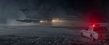 Movie still from “Die Hard 2” (1990), directed by Renny Harlin – An american trans air plane on a snowy night; Extreme Wide shot, Low angle