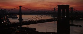 Movie still from “Die Hard with a Vengeance” (1995), directed by John McTiernan – A view of a bridge and a city at night; Extreme Wide shot, High angle