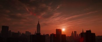 Movie still from “Die Hard with a Vengeance” (1995), directed by John McTiernan – The sun is setting over a city skyline; Extreme Wide shot, Low angle