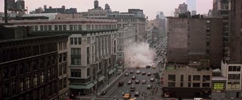 Movie still from “Die Hard with a Vengeance” (1995), directed by John McTiernan – A city street filled with lots of smoke coming out of it; Extreme Wide shot, High angle