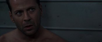 Movie still from “Die Hard with a Vengeance” (1995), directed by John McTiernan – A man with no shirt is looking at the camera; Close Up shot, Low angle