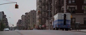 Movie still from “Die Hard with a Vengeance” (1995), directed by John McTiernan – A street scene with a police van driving down the street; Extreme Wide shot, High angle