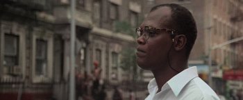 Movie still from “Die Hard with a Vengeance” (1995), directed by John McTiernan – A person wearing glasses looking up; Close Up shot, Low angle