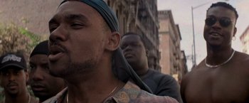 Movie still from “Die Hard with a Vengeance” (1995), directed by John McTiernan – A man with a blue bandana on his head and a man with a blue bandana on his face; Close Up shot, Low angle