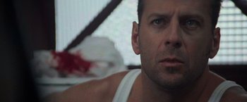 Movie still from “Die Hard with a Vengeance” (1995), directed by John McTiernan – A man's face in a white shirt; Close Up shot, Low angle