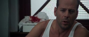 Movie still from “Die Hard with a Vengeance” (1995), directed by John McTiernan – A person in a white shirt; Close Up shot, Over the shoulder angle