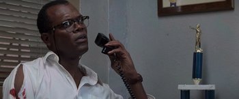 Movie still from “Die Hard with a Vengeance” (1995), directed by John McTiernan – A man talking on a phone while wearing glasses; Close Up shot, Low angle