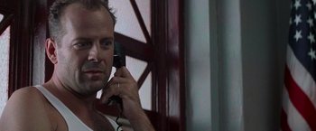 Movie still from “Die Hard with a Vengeance” (1995), directed by John McTiernan – A person talking on a phone; Close Up shot, Low angle
