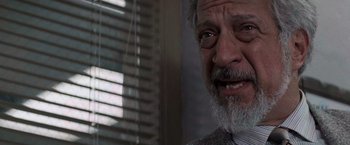 Movie still from “Die Hard with a Vengeance” (1995), directed by John McTiernan – An older man with a beard and a gray tie; Close Up shot, Low angle