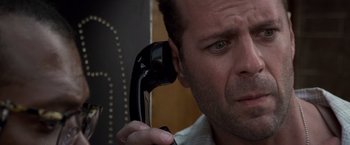 Movie still from “Die Hard with a Vengeance” (1995), directed by John McTiernan – A person holding a phone up to their ear; Close Up shot, Low angle