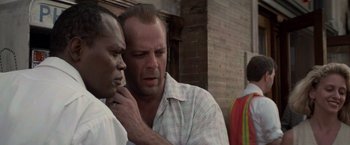 Movie still from “Die Hard with a Vengeance” (1995), directed by John McTiernan – A man and a woman standing next to each other outside; Close Up shot, Low angle
