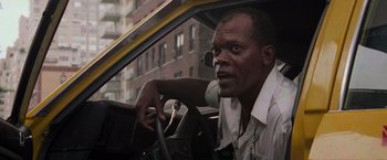 Movie still from “Die Hard with a Vengeance” (1995), directed by John McTiernan – A man sitting in the driver's seat of a taxi cab; Close Up shot, Low angle