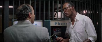 Movie still from “Die Hard with a Vengeance” (1995), directed by John McTiernan – A man is talking to another man in front of a phone booth; Close Up shot, Low angle