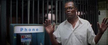 Movie still from “Die Hard with a Vengeance” (1995), directed by John McTiernan – A man in a white shirt is holding his hand up; Close Up shot, Over the shoulder angle