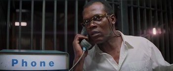 Movie still from “Die Hard with a Vengeance” (1995), directed by John McTiernan – A man talking on a phone in front of a computer; Close Up shot, Low angle