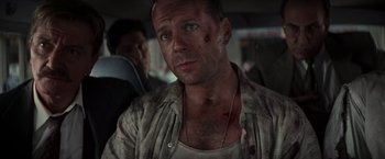 Movie still from “Die Hard with a Vengeance” (1995), directed by John McTiernan – A person wearing a shirt and tie; Close Up shot, Over the shoulder angle