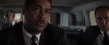 Movie still from “Die Hard with a Vengeance” (1995), directed by John McTiernan – A person wearing a suit and tie; Close Up shot, Low angle