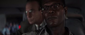 Movie still from “Die Hard with a Vengeance” (1995), directed by John McTiernan – A man with glasses and a man with a tie; Close Up shot, Low angle