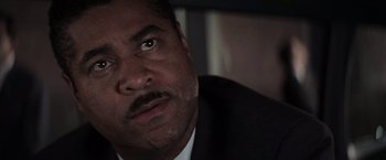 Movie still from “Die Hard with a Vengeance” (1995), directed by John McTiernan – A person wearing a suit and tie; Close Up shot, Low angle