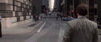 Movie still from “Die Hard with a Vengeance” (1995), directed by John McTiernan – A city street with a crowd of people walking down it; Wide shot, Over the shoulder angle