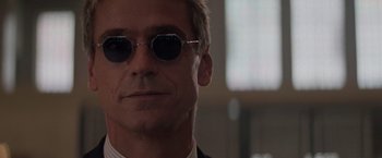 Movie still from “Die Hard with a Vengeance” (1995), directed by John McTiernan – A person wearing a suit and sunglasses; Close Up shot, Low angle