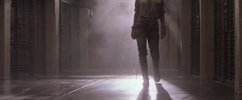 Movie still from “Die Hard with a Vengeance” (1995), directed by John McTiernan – A person walking in a room with smoke coming out of the ceiling; Wide shot, Low angle