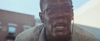 Movie still from “Die Hard with a Vengeance” (1995), directed by John McTiernan – A man's face with glasses; Close Up shot, Low angle