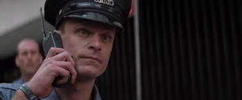 Movie still from “Die Hard with a Vengeance” (1995), directed by John McTiernan – A man in a police uniform is looking at the camera; Close Up shot, Low angle