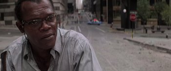 Movie still from “Die Hard with a Vengeance” (1995), directed by John McTiernan – A person wearing glasses on the street; Close Up shot, Low angle