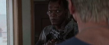 Movie still from “Die Hard with a Vengeance” (1995), directed by John McTiernan – A man holding a gun in front of a bathroom mirror; Close Up shot, Over the shoulder angle