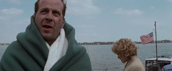 Movie still from “Die Hard with a Vengeance” (1995), directed by John McTiernan – A man and a woman are standing in front of a body of water; Close Up shot, Over the shoulder angle