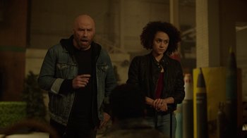 Movie still from “Die Hart” (2023), directed by Eric Appel – A man and a woman standing next to each other in a room; Medium shot, Over the shoulder angle