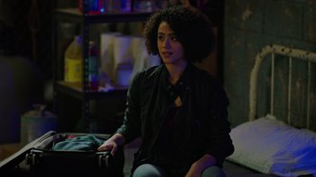 Movie still from “Die Hart” (2023), directed by Eric Appel – A woman sitting on the ground in a room; Medium shot, Over the shoulder angle