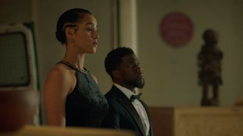 Movie still from “Die Hart” (2023), directed by Eric Appel – A man and a woman standing next to each other; Medium shot, Low angle