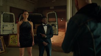 Movie still from “Die Hart” (2023), directed by Eric Appel – A man and a woman standing in front of a white van; Medium shot, Over the shoulder angle